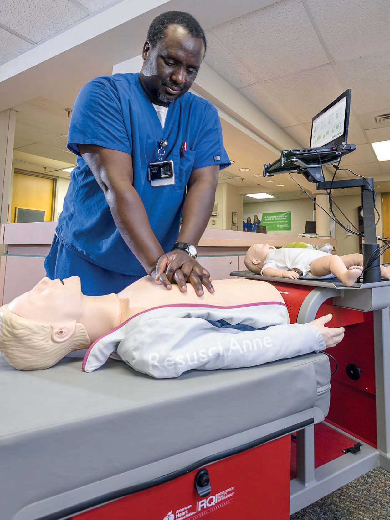 A man preforming CPR on a Anna doll